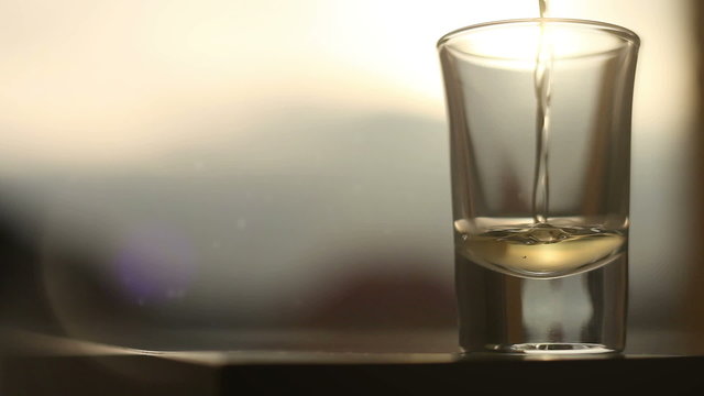 Potent alcoholic beverage being poured into glass