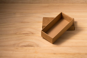 Opened cardboard box on wooden background