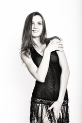 Fototapeta premium Black and white. Beautiful sexy brunette girl in the studio on a white background in a transparent black dress