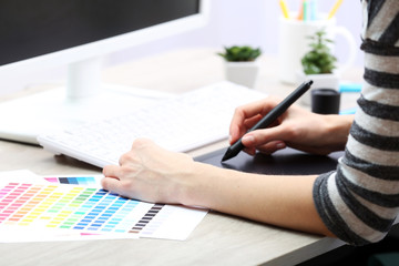 Female hand drawing on the graphic tablet in the office, close-up