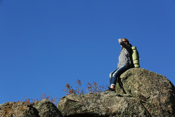 Woman sitting on the top of the mountain