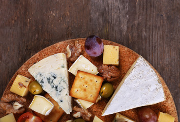 Different kinds of cheese on wooden background