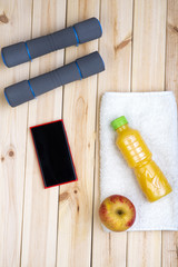 Sport Equipment. Dumbbells, Orange Juice, White Towel, Apple And Phone On Boards.