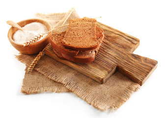 Sliced bread with ears and flour on napkin isolated on white