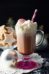 Cup of coffee with whipped cream and sweets on black table