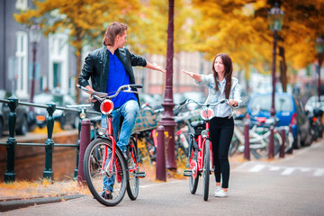 Young happy caucasian couple on bikes in Amsterdam