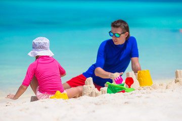 Happy family playing with beach toys on summer vacation