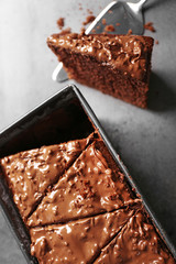 Delicious chocolate cake with nut cream on grey background, close up