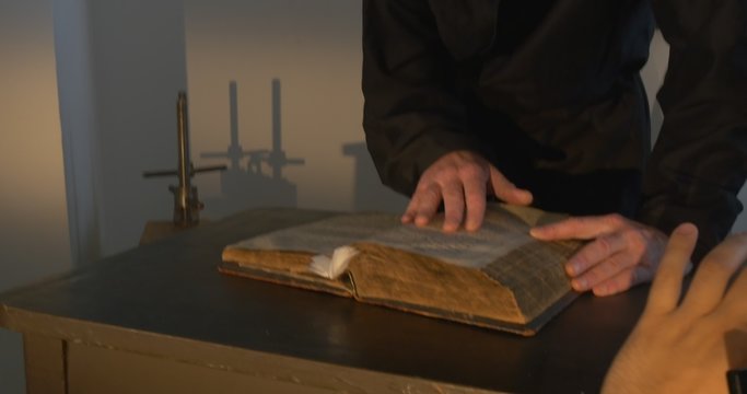 Monk, Man in Black, Hands Closeup, Touches The Book, Nestor the Chronicler's book "The Tale of Bygone Years", Kievo-Pechersky Paterik