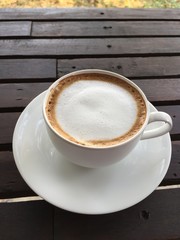 cup of coffee with milk on wood table