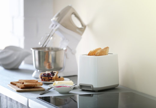 Toaster with mixer and sandwiches on a light kitchen table