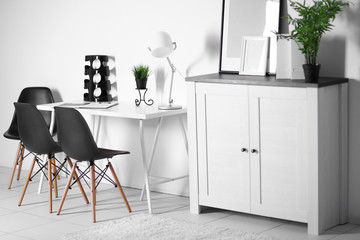 Room interior with commode, frames, chairs and table on white wall background