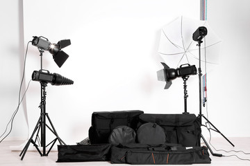 Empty photo studio with lighting equipment,  bags and backdrop