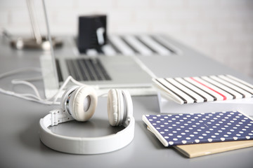 Headphones and laptop on gray table against defocused background