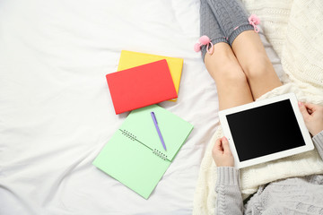 Woman using tablet on her bed