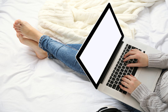 Woman Using Laptop On Her Bed