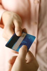 Hands holding blue credit card on white background