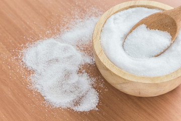 White salt in wooden bowl ,on wooden table