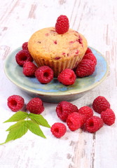 Fresh baked cupcake with raspberries and fruits on old wooden background, delicious dessert