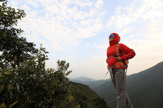 young woman hiker hiking at mountain peak