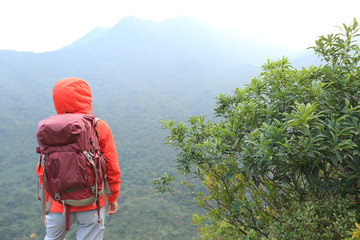 Fototapeta na wymiar young woman backpacker hiking on mountain peak