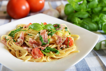 Spaghetti pasta with rucola, cherry tomatoes and prosciutto ham