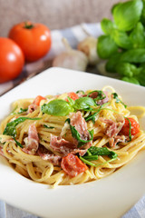 Spaghetti pasta with rucola, cherry tomatoes and prosciutto ham