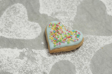Cookie with blue icing on baking paper powdered with sugar