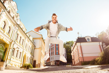 Cheerful free man jumping on the street and screaming
