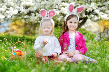 Two adorable little sisters playing with Easter eggs on Easter day