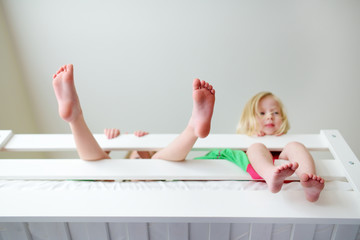 Two little sisters fooling around, playing and having fun in twin bunk bed - obrazy, fototapety, plakaty