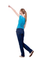 back view of walking  woman  in   jeans and shirt pointing