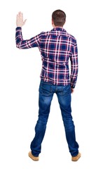 Back view of handsome man in checkered shirt  looking up.