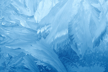 Fototapeta na wymiar Frost patterns on window glass in winter. Frosted Glass Texture. Blue