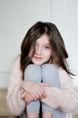 Portrait of beauty school aged brunette kid girl with blue eyes indoor