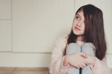 Portrait of beauty school aged brunette kid girl with blue eyes indoor