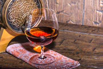 Barrel with a glass of cognac on the old table