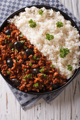 Picadillo a la habanera with rice close-up on the table. Vertical top view 
