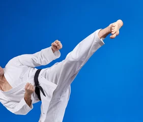 Foto op Plexiglas High kick athlete is beating with a black belt © andreyfire