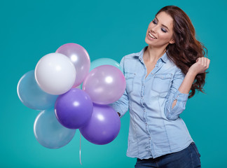 Woman with balloons in studio on a blue background