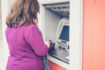 Back view of woman using atm