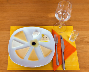 Variety of cheese presented on a plate on a wooden table