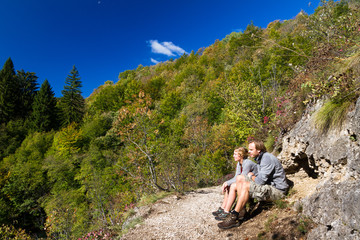A couple of hikers resting in UNESCO world heritage site national park Plitvice in Croatia in autumn