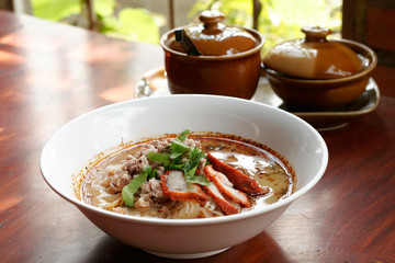 Spicy TOM YAM noodle soup with pork, lemongrass, chili pasted an