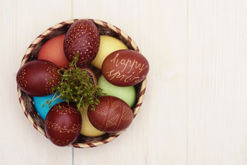 Straw bowl full of easter decorations.