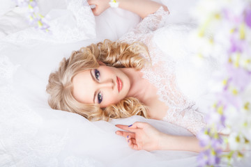 Obraz na płótnie Canvas photo of a beautiful blonde bride in a luxurious wedding dress in elegant expensive interior