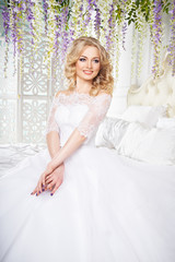 Naklejka na ściany i meble photo of a beautiful blonde bride in a luxurious wedding dress in elegant expensive interior