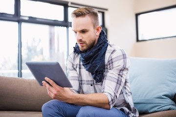 Handsome man using tablet on the couch 