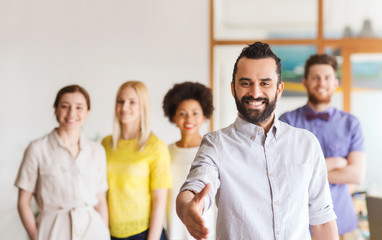 happy man making handshake over office team