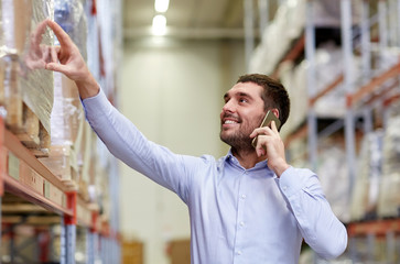 happy man calling on smartphone at warehouse